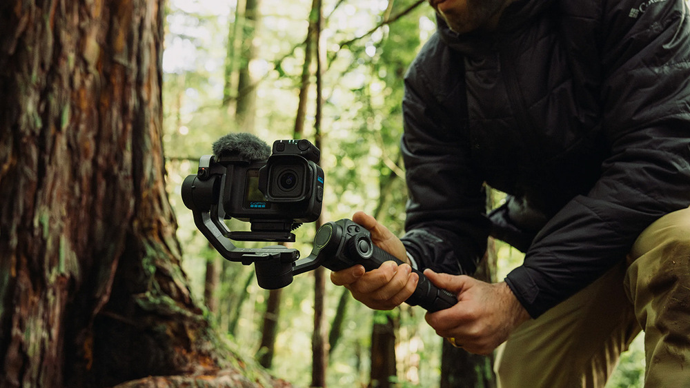 Mikrofon GoPro Media Mod MISSION 1 černé Muž natáčející kamerou GoPro na stabilizátoru v lese