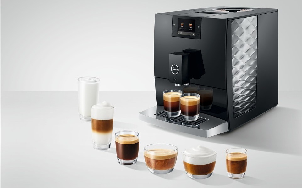 Automatický kávovar Jura C9 Piano Black černý Automatický kávovar Jura C9 Piano Black chystá dvě sklenice kávy, před kávovarem stojí šest sklenic s různými druhy kávy