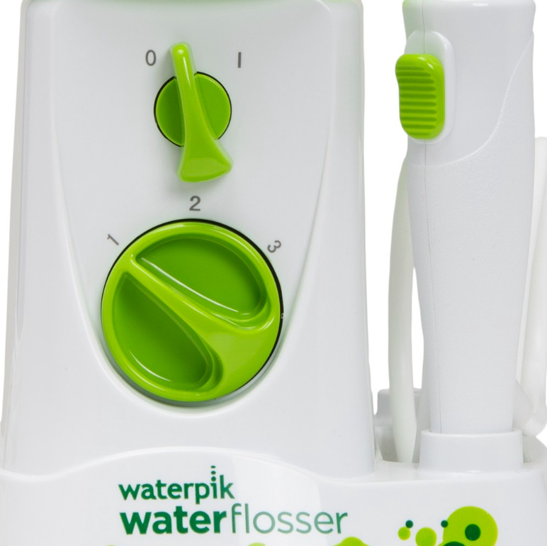 Ústní sprcha Waterpik WP260E2 Kids bílá/zelená Detail vypínače, voliče tří úrovní tlaku a tlačítka na rukojeti ústní sprchy