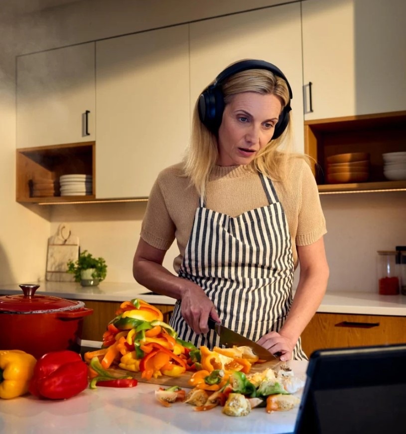 Sluchátka Sennheiser RS275 TV černá Žena krájící papriku sleduje video na tabletu a má nasazená sluchátka Sennheiser RS275 TV