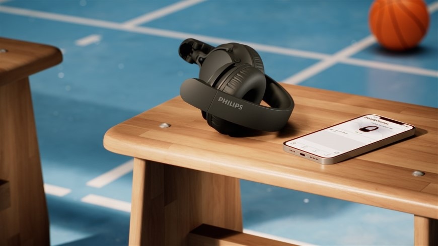 Sluchátka Philips TAH4000LB/00 světle modrá Složená sluchátka Philips položená na lavici vedle chytrého telefonu