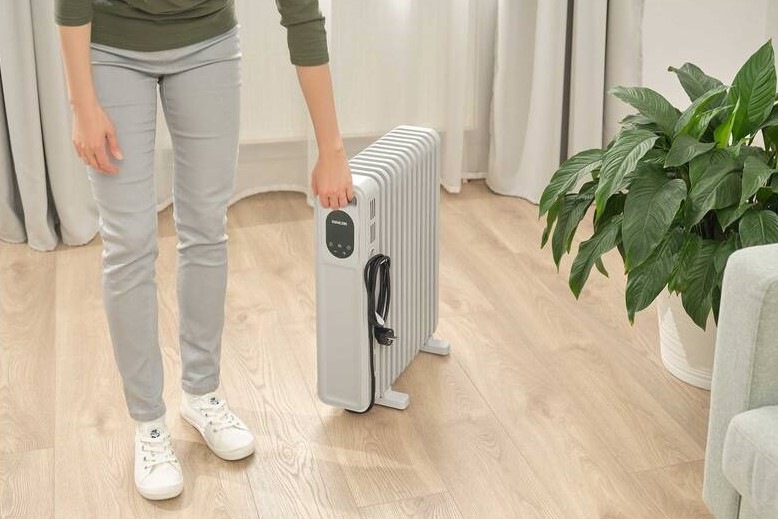 částečně viditelná postava muže uchopuje integrovaný úchyt radiátoru pro snadný přenos