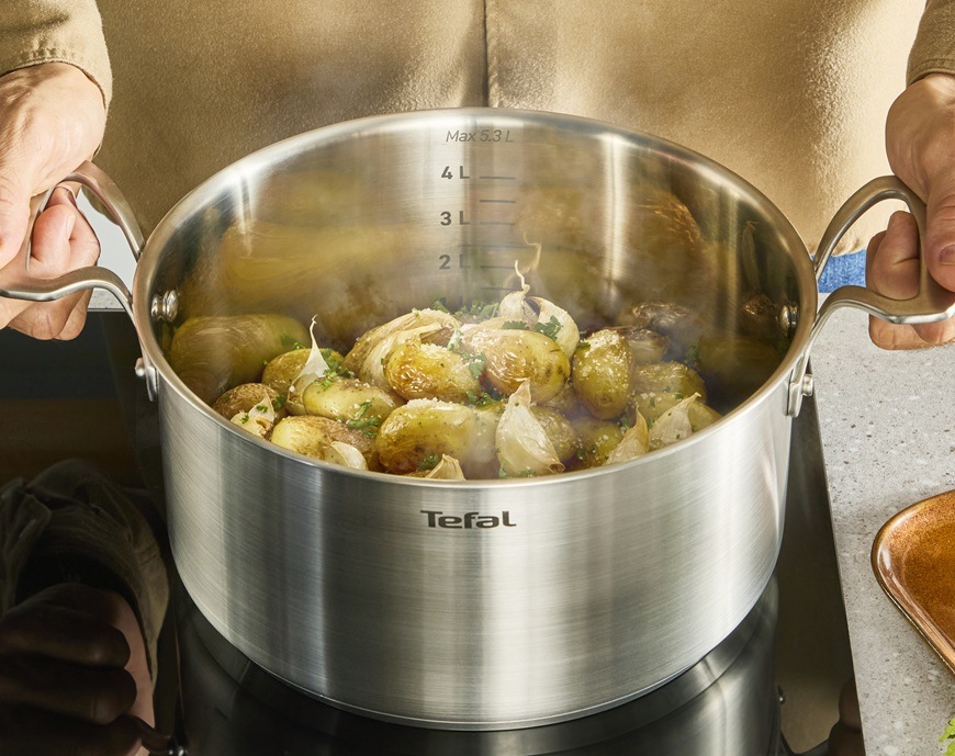 Hrnec s poklicí Tefal Extreme E5294304, 18 cm nerez Muž vaří brambory v kastrolu značky Tefal.