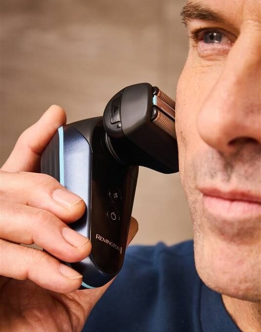 Holicí strojek na hlavu Remington Balder XF8000 černý Detailní pohled na muže, který drží v ruce Remignton XF8000 Balder a holí si obličej.