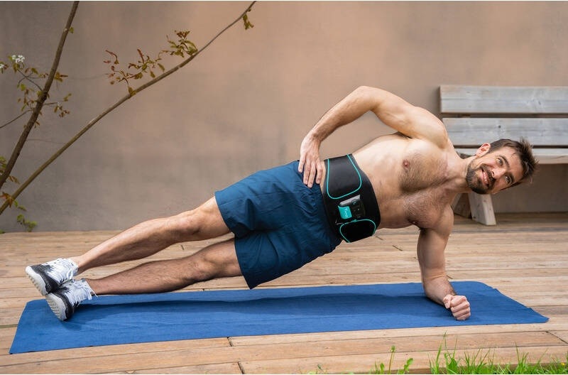 Elektrostimulátor Beurer Corefit I černý Muž cvičí boční plank na podložce s nasazeným břišním pásem Beurer Corefit I