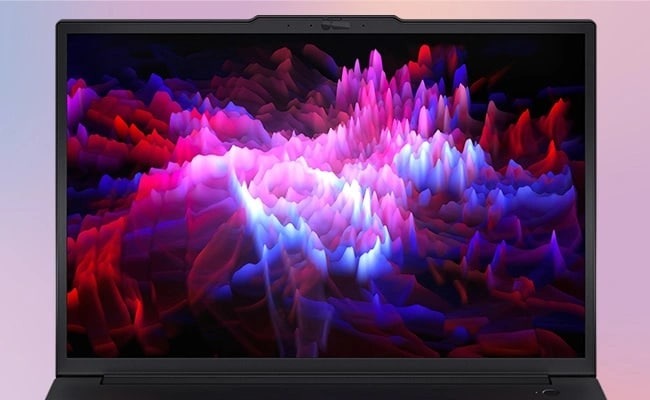 Displej notebooku zobrazuje živou, abstraktní 3D vlnovou formu v odstínech růžové, fialové a červené barvy, která vytváří dynamický a energický vizuální efekt.