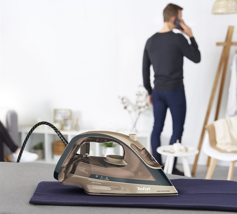 Muž žehlí, když v tom mu zazvonil telefon. I když nechal žehličku položenou na oděvu, tak se nic nestane, funkce automatického vypnutí při nečinnosti zařízení vypíná.