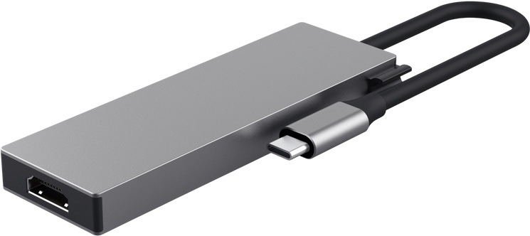 USB Hub Trust DALYX 5v1 stříbrný Na obrázku je stříbrný USB-C hub Trust DALYX 5v1 zachycený zezadu a mírně z boku. Má úzké kovové tělo s čistým hranatým designem, na levém čele je vidět HDMI konektor. Z druhé strany vychází krátký pevný kabel zakončený USB-C konektorem pro připojení k notebooku nebo tabletu. Z
