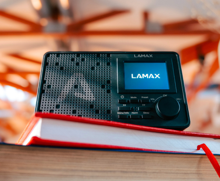 Radiopřijímač DAB+ LAMAX RadioVox1 DAB položený na knize s barevným TFT displejem