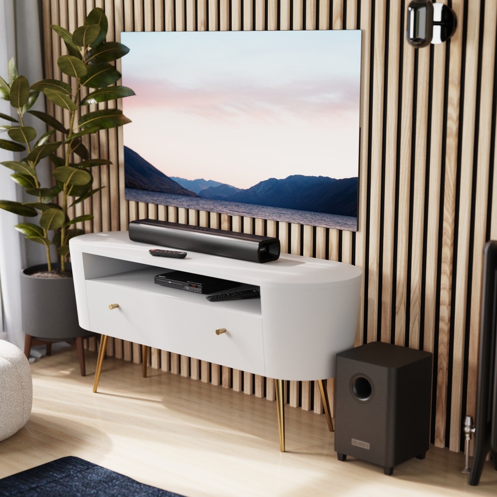 Soundbar Majority Naga černý Soundbar Majority Naga 60 Plus pod televizorem a bezdrátový subwoofer vedle stolku.