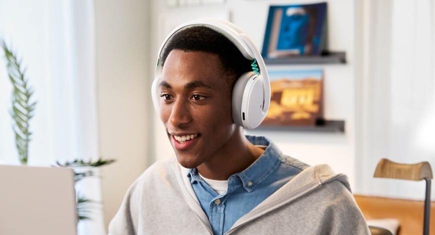 Hráč při hraní hry u notebooku používá herní headset Logitech G325 LIGHTSPEED Wireless