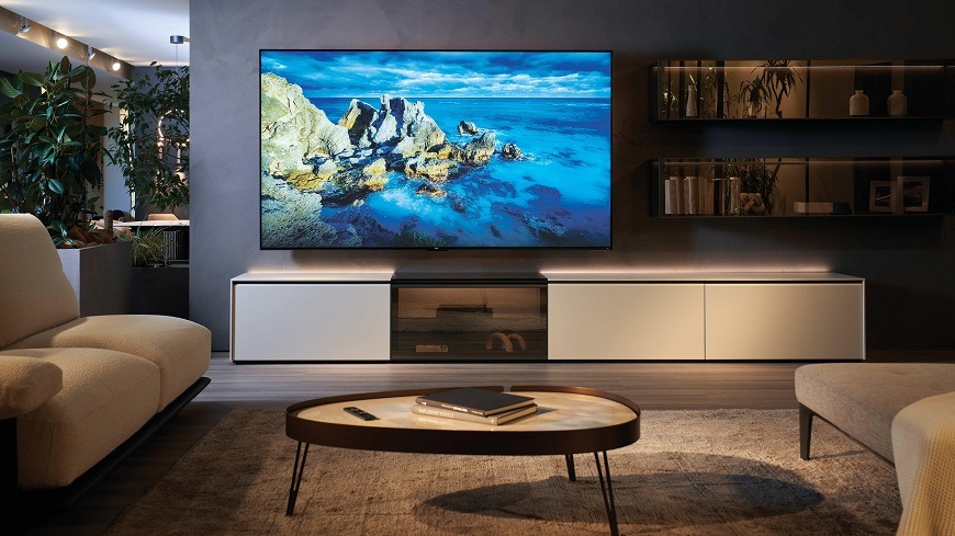 Televize Haier H100S90FUX v obýváku s obrazem přírodní krajiny