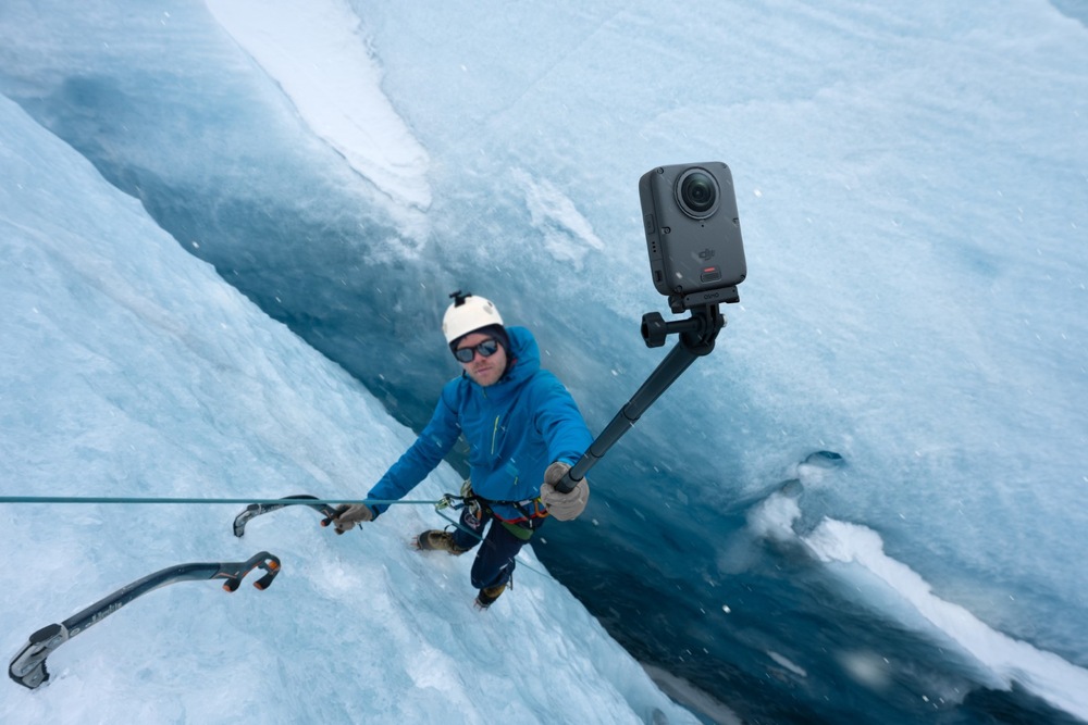 Outdoorová kamera DJI Osmo 360 II Adventure Combo černá Horolezec na strmé ledové stěně si pořizuje selfie pomocí akční kamery na neviditelné selfie tyči