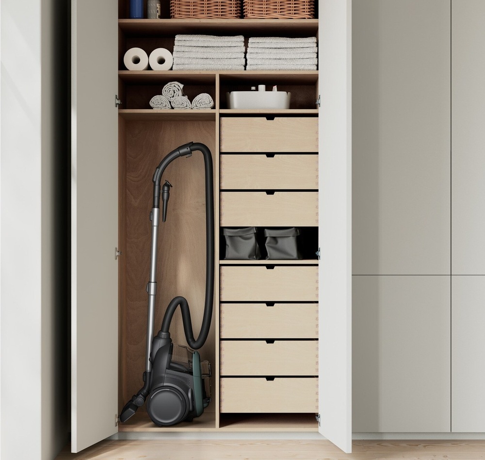 Vysavač Electrolux EL61C2OG série 600 Clean svisle uložený ve skříni. Kolem jsou šuplíky a police. 