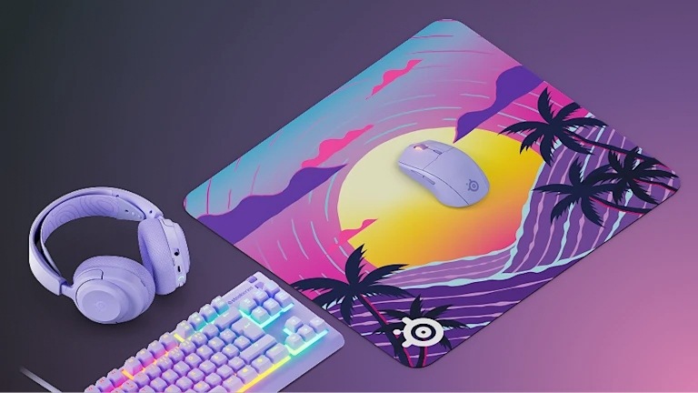 Podložka pod myš SteelSeries QcK Large, Neon Sunset fialová Myš na podložce QcK Large Neon Sunset vedle headsetu a klávesnice s RGB podsvícením