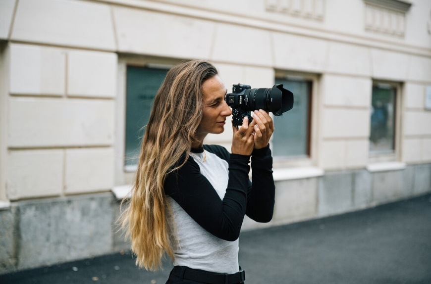 Žena fotografuje za použití skla NIKKOR Z DX 16–50 mm f/2.8 VR