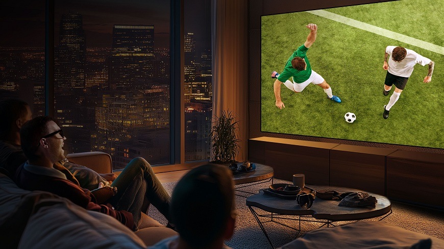 lidé sledují fotbal na televizi Hisense 85E7S, která visí na stěně v obýváku