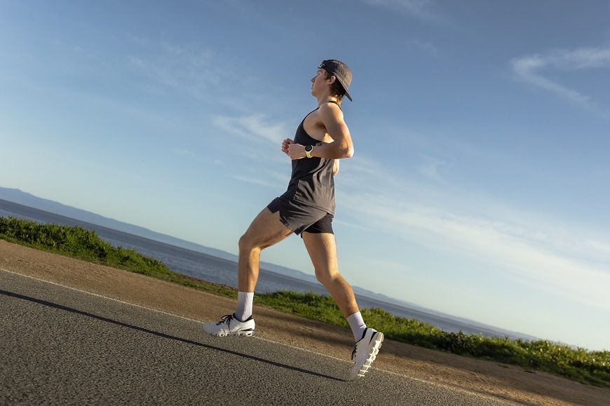 Žena běží s hodinkami Garmin Forerunner 70