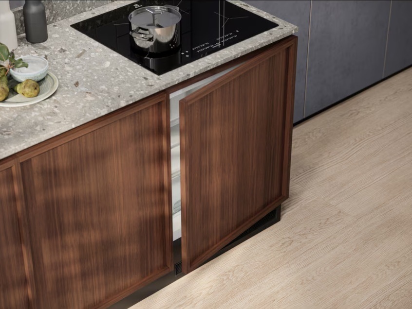 Vestavná lednice Electrolux s dřevěnou dekorační deskou. Nad lednicí je v lince umístěna indukční varná deska Electrolux.