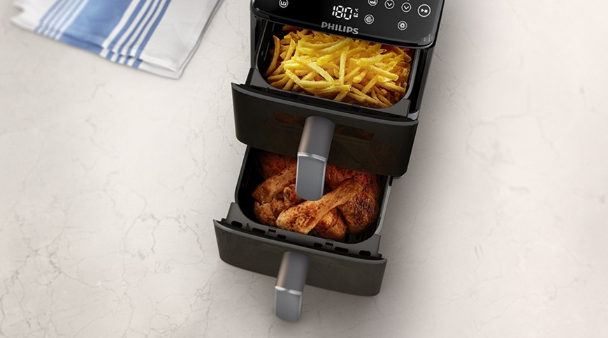 Fritéza horkovzdušná Philips Airfryer Dual Basket 4000 series 10 l, NA461/00 černá Pohled shora na horkovzdušnou fritézu Philips NA461/00 se dvěma vysunutými koši, v horním koši jsou hranolky a ve spodním koši pečené kuřecí paličky.
