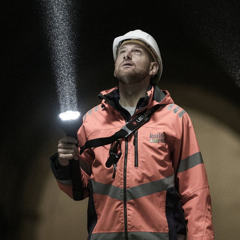 Svítilna LEDLENSER P21R černá Muž s rozsvícenou svítilnou LEDLENSER P21R vzhlíží k místu, na které dopadá silný paprsek