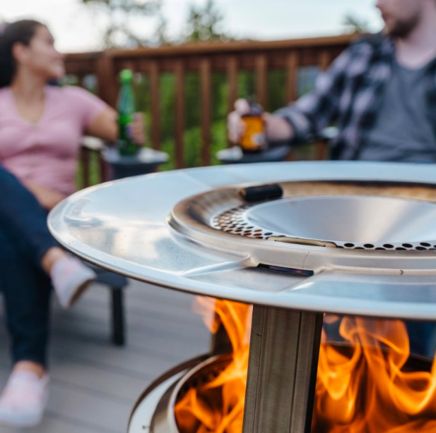 Detail nerezového rozptylového disku deflektoru Solo Stove Ranger nad plameny ohně