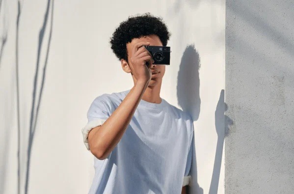 Digitální fotoaparát Fujifilm X half stříbrný Fotograf pořizuje snímek kompaktním fotoaparátem Fujifilm X half, který díky malým rozměrům padne pohodlně do ruky