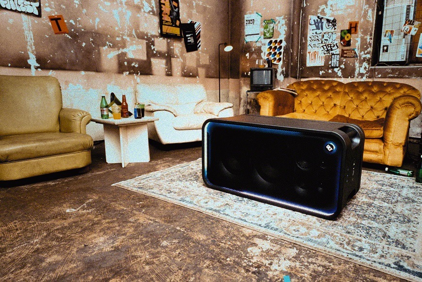 Party reproduktor Sony ULT TOWER MAX umístěný vodorovně na podlaze v obývacím prostoru
