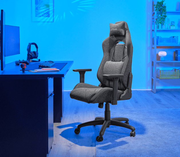 Herní židle Trust GXT 723 RUYA Fabric stojící v pokoji u herního stolu