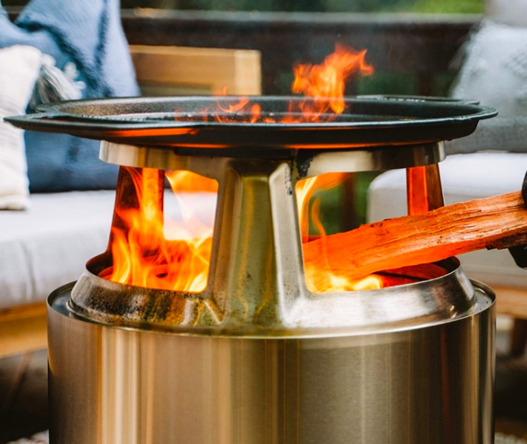 Detail ohniště Solo Stove Bonfire s litinovým grilovacím roštem nad otevřeným plamenem