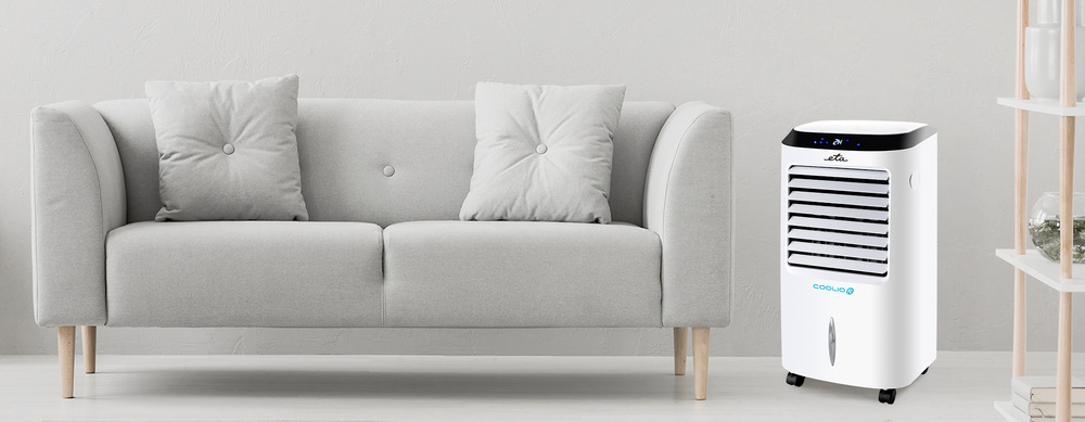 Ochlazovač vzduchu ETA Coolio 0568 90000 bílý Ochlazovač vzduchu ETA Coolio v moderním interiéru, umístěný vedle šedého gauče