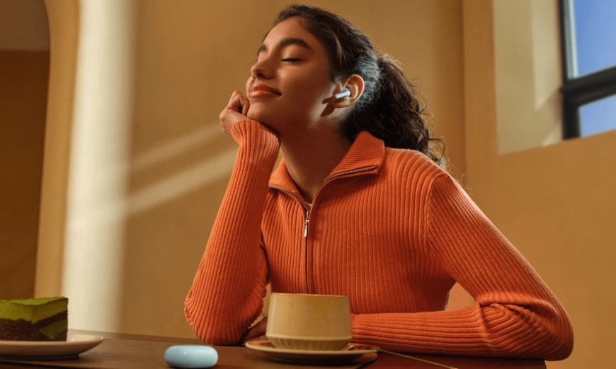 Sluchátka Xiaomi REDMI Buds 8 Active modrá Relaxující žena s dezertem a šálkem kávy má v uchu sluchátko REDMI Buds 8 Active