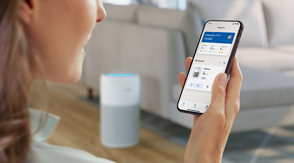 Žena drží v ruce smartphone s mobilní aplikací Air+