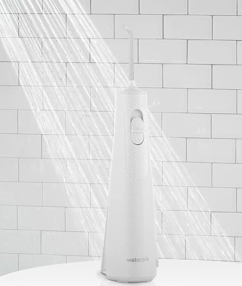 Voděodolná ústní sprcha Waterpik WF26EU stojí pod proudem vody ve sprše