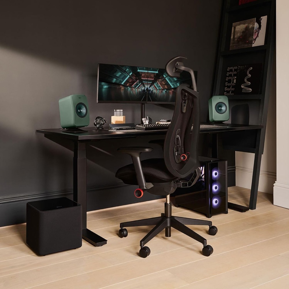 Subwoofer KEF Kube 8 MIE (1 ks) černý Černý subwoofer KEF Kube 8 MIE umístěný pod herním stolem se širokoúhlým monitorem, zelenými reproduktory a počítačem s RGB podsvícením.