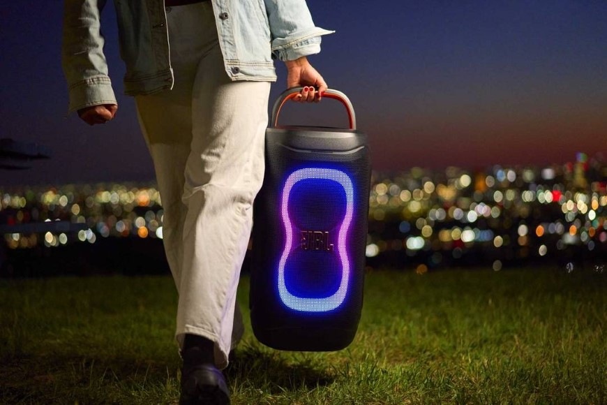 Party reproduktor JBL PARTYBOX 130 bílý Osoba nesoucí reproduktor PartyBox 130 s ergonomickým madlem