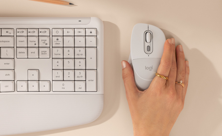 Světlá varianta Logitech Signature M850 L Wireless vedle klávesnice na pracovním stole