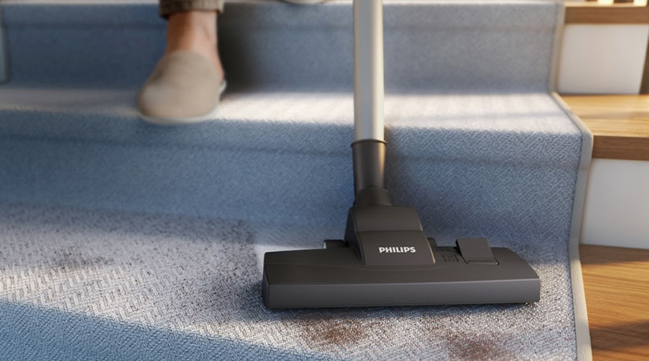 Sáčkový vysavač Philips XD1111/10 1000 Series vysává nečistoty ze špinavého koberce.
