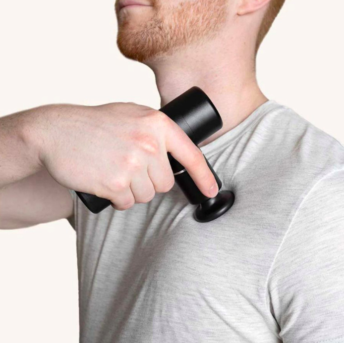 Muž si plochou hlavicí masážní pistole Swedish Posture SP-241035 promasírovává rameno