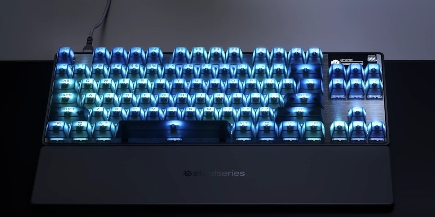Klávesnice SteelSeries Apex Pro TKL Gen 3 Steel - US černá Apex Pro TKL Gen 3 Steel s modře podsvícenými klávesami a připojenou opěrkou zápěstí