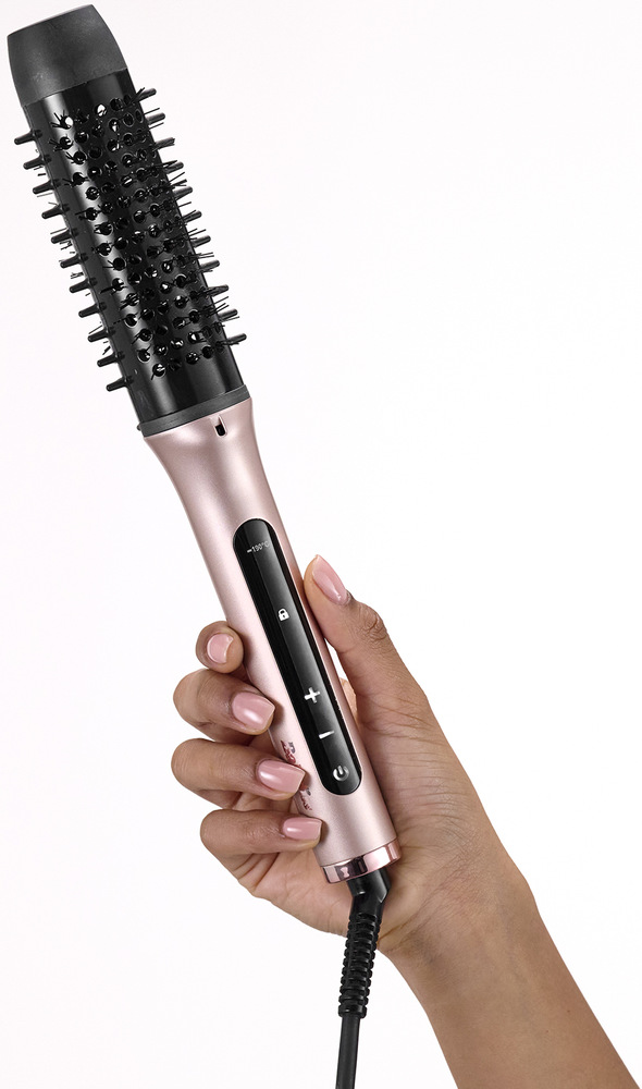 Žehlicí kartáč BaByliss HSB200E růžová Ruka držící žehlící kartáč.