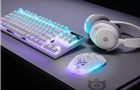 Bílá myš SteelSeries Aerox 3 Wireless Gen 2 vedle headsetu a klávesnice SteelSeries