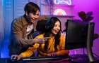 Dva lidé se dívají na herní monitor při hraní hry